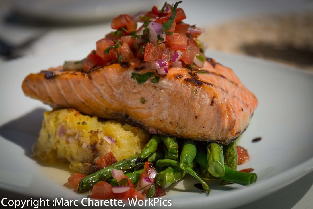 Commercial food photography of plated salmon in waterfront restaurant