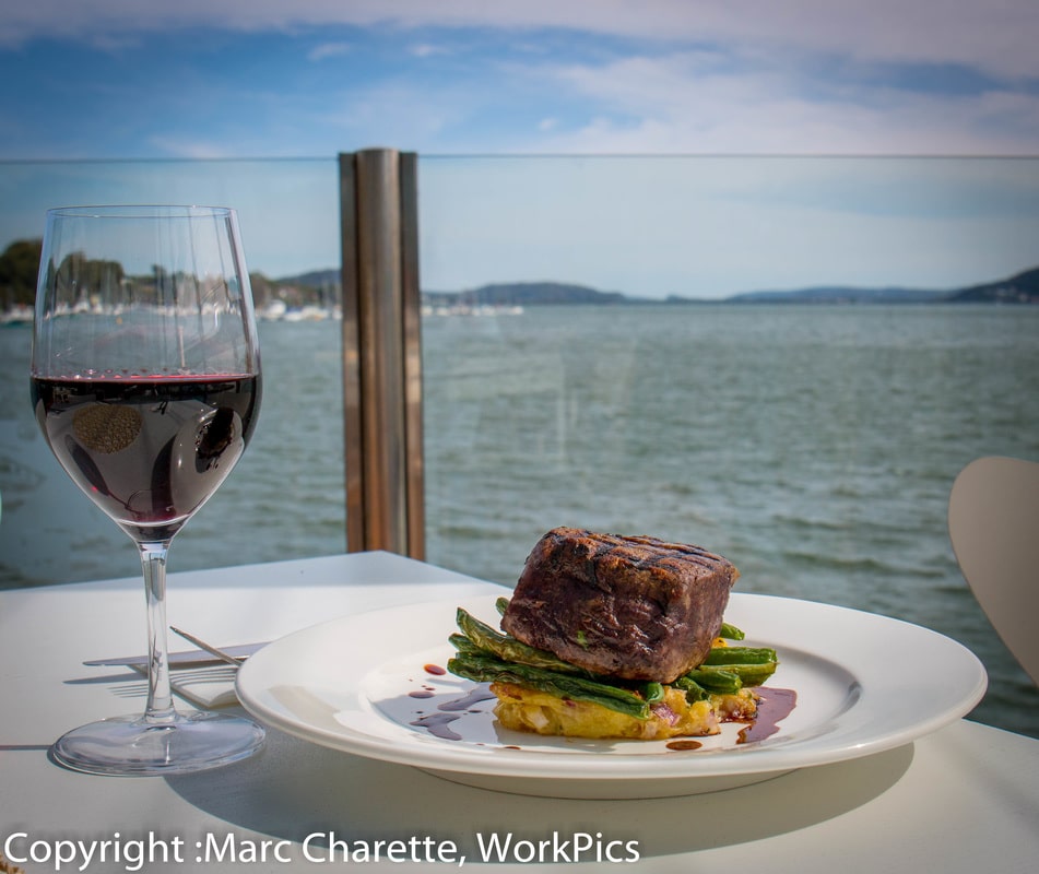 Commercial photography of beer and wine with a view at waterfront restaurant