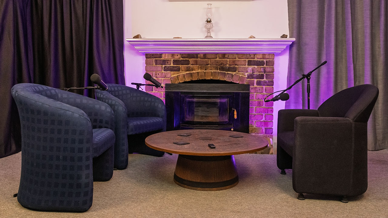 Studio set for 2 guests and one host in front of fireplace